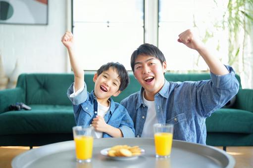 カメラ目線でガッツポーズして楽しそうな親子 カメラ目線でガッツポーズして楽しそうな親子の写真