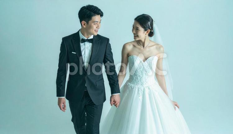 結婚式で手をつないで歩く新郎新婦 夫婦,タキシード,ウェディングの写真素材