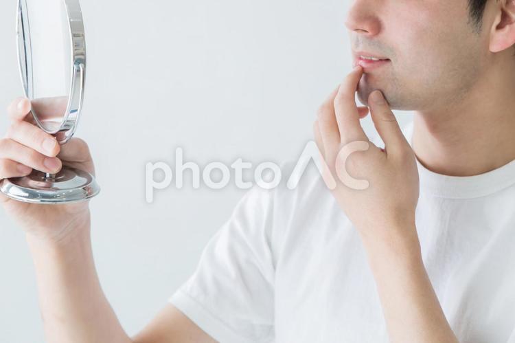 あごの辺りを気にする男性 顎,唇,乾燥の写真素材