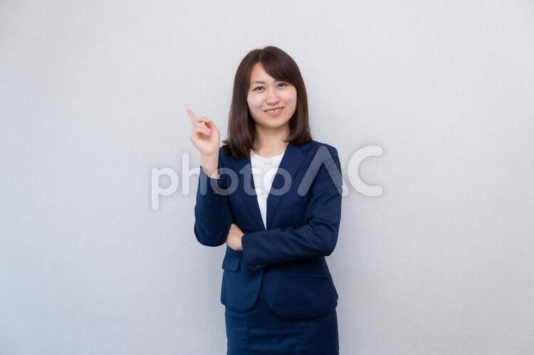 何か閃いて人差し指をさすスーツの女性 女性,スーツ,olの写真素材