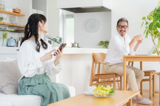 リビングでスマホを見るミドルの夫婦 リビングでスマホを見るミドルの夫婦の写真