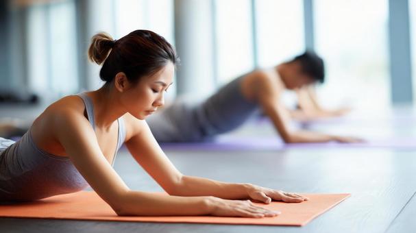 ジムでストレッチする男女の写真