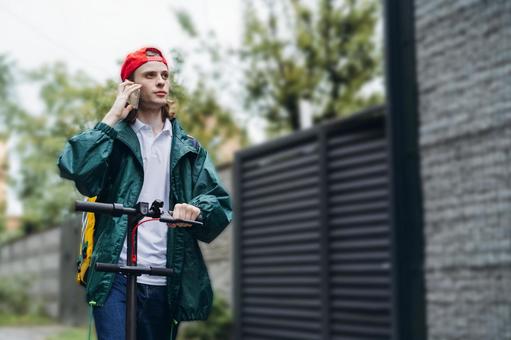 スマートフォンで電話しているフードデリバリーの男性 配達,フードデリバリー,デリバリーの写真素材