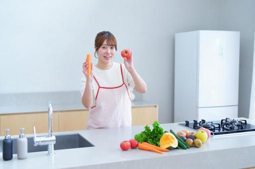 リンゴとトマトを持つカメラ目線の女性 女性,リンゴ,ニンジンの写真素材