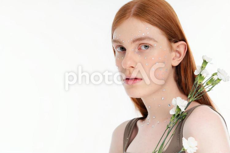 白いカーネーションとカメラ目線女性 女性,花,カーネーションの写真素材