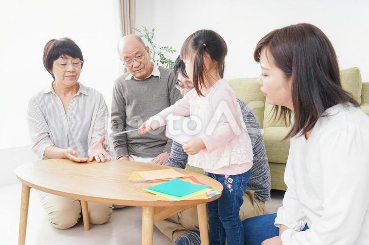 折り紙で遊ぶ子供と家族 一人娘,祖父母,紙の写真素材