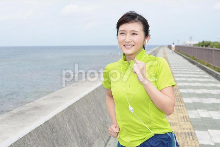 海岸でジョギングを楽しむ女性 沖縄,女性,女の写真素材