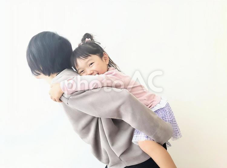 母におんぶされて嬉しそうな笑顔の女の子 親子,笑顔,おんぶの写真素材