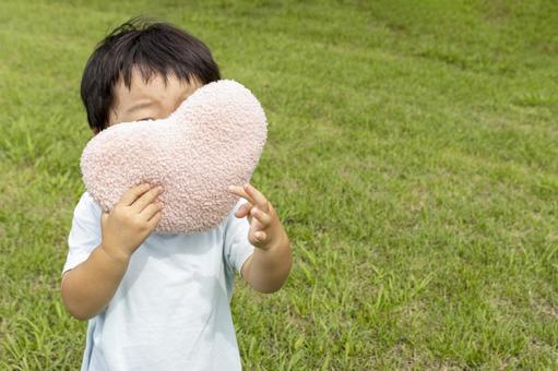 ハート持って草原に立つ男の子（顔無し） 男の子,ハート,愛の写真素材