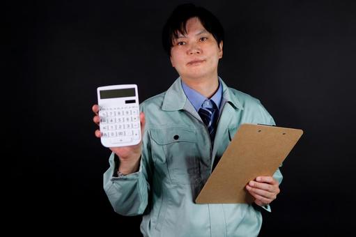 作業服の男性が電卓を持つ 作業服の男性が電卓を持つ 作業服,男性,電卓の写真素材