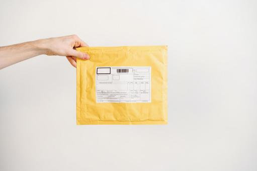 クッション封筒を差し出す手 配達,デリバリー,郵便の写真素材