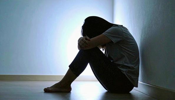 部屋で落ち込んで座る日本人女性の横顔 部屋で落ち込んで座る日本人女性の横顔の写真