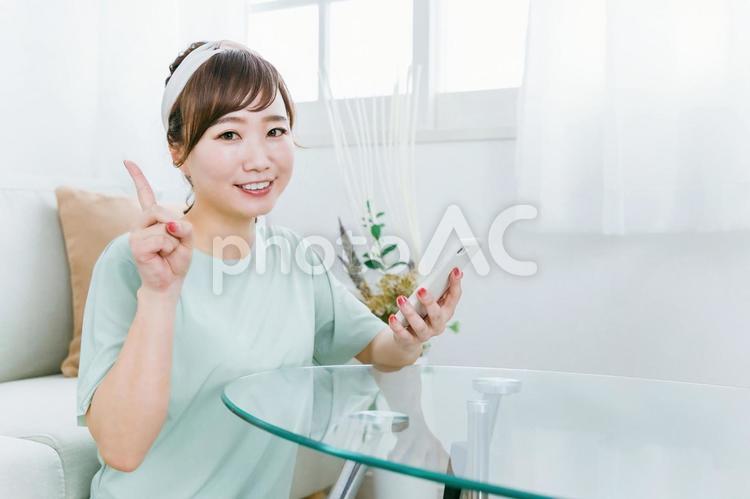 スマホを使う笑顔の日本人女性（アプリ） スマホ,女性,スマートフォンの写真素材