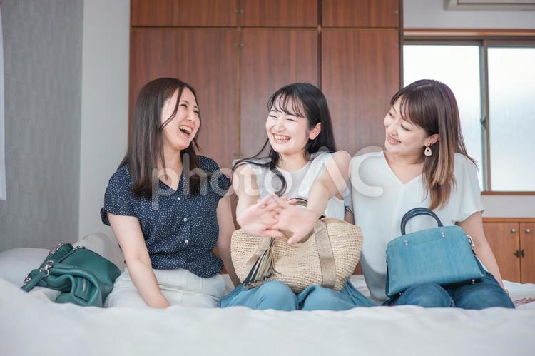 旅行の宿泊先に着いた女性たち（ベッド） 旅行,旅,女子旅の写真素材