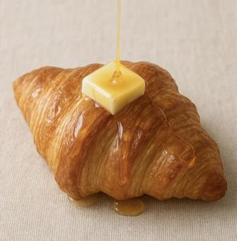 バターとハチミツをかけたクロワッサン バターとハチミツをかけたクロワッサンの写真