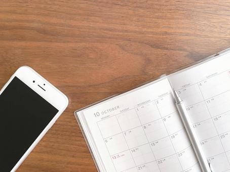 机上のスマホと10月のスケジュール帳 カレンダー,手帳,予定の写真素材