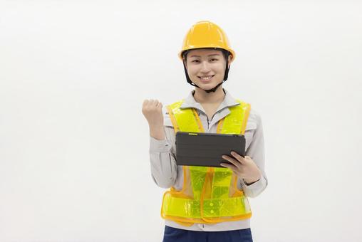 タブレットを使う作業服の女性 タブレットを使う作業服の女性 女性,作業員,ヘルメットの写真素材