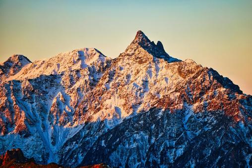 朝焼けの冠雪の北アルプスの槍ヶ岳 朝焼け,モルゲンロート,冠雪の写真素材