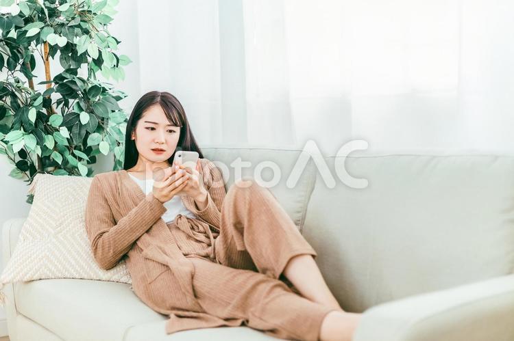 スマホを見てショックを受ける日本人女性 スマホ,悲しい,ショックの写真素材