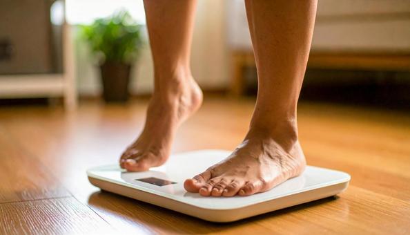 白い体重計に足を乗せる若い女性 白い体重計に足を乗せる若い女性 体重測定,女性,ヘルスケアの写真素材