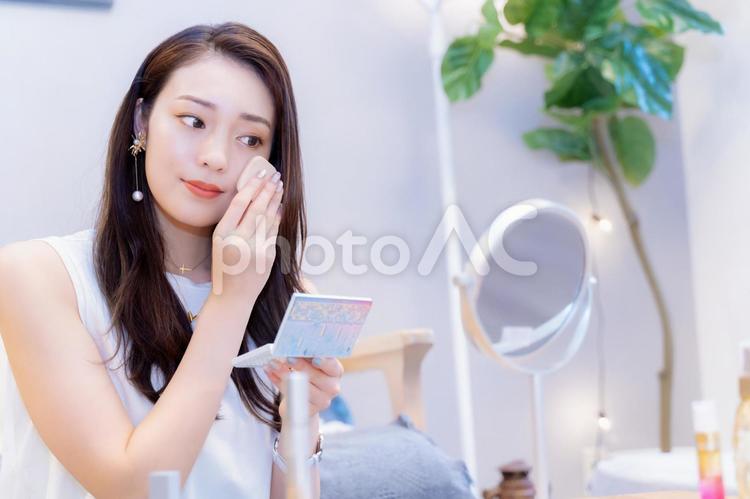 ファンデーションを塗ってメイクをする20代の女性 化粧,女性,メイクの写真素材