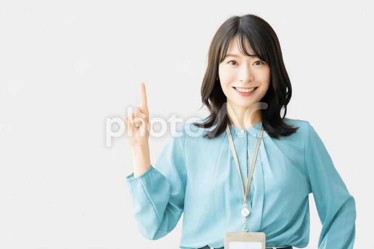 人差し指を立てて案内するビジネスウーマン 女性,笑顔,案内の写真素材