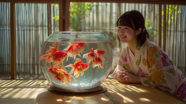 水槽を泳ぐ金魚と浴衣を着た女性 水槽を泳ぐ金魚と浴衣を着た女性の写真