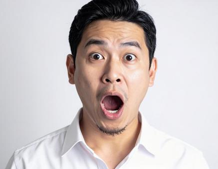 口を開けて驚く男性 口を開けて驚く男性の写真