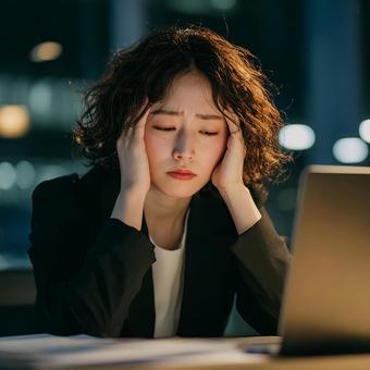 深夜まで働く女性の頭痛と疲労 深夜まで働く女性の頭痛と疲労の写真