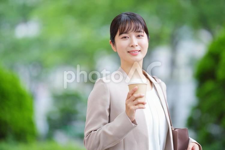 カメラ目線でコーヒーを持った女性 女性,人物,大学生の写真素材