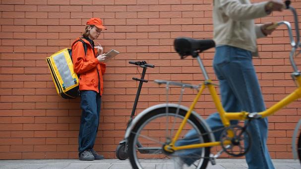 タブレットを見ているフードデリバリーの男性 配達,フードデリバリー,デリバリーの写真素材