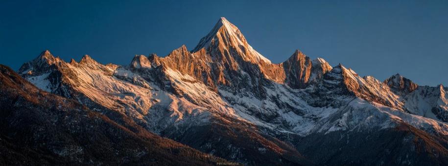 神々しい光に包まれた、雪化粧の山々の景色の写真