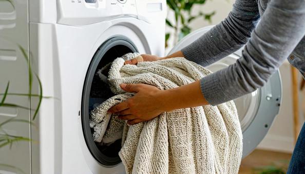 洗濯機から洗濯物を取り出す女性の手 洗濯機から洗濯物を取り出す女性の手の写真