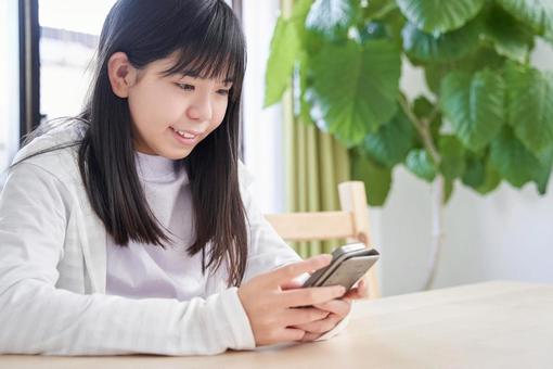 Japanese girls junior high school students looking at smartphones in the living room, JPG Japanese girls junior high school students looking at smartphones in the living room, JPG