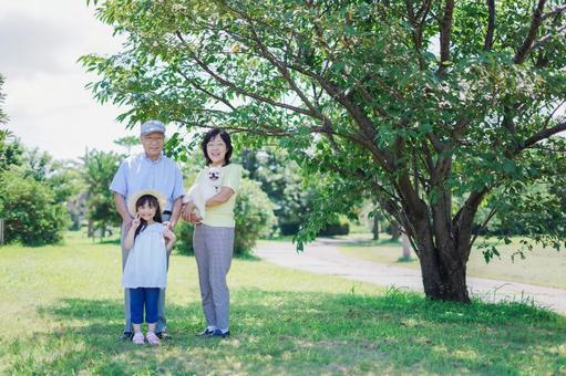 祖父母と外で遊ぶ小さな女の子 祖父母と外で遊ぶ小さな女の子 子犬,シニア,元気の写真素材