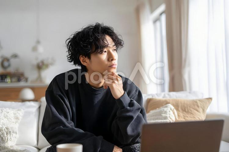 自宅で思索にふける若いアジア人男性 若いアジア人男性,思索,考えるの写真素材