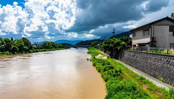 台風の後、増水して濁った川と青空 台風の後、増水して濁った川と青空の写真