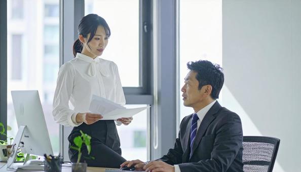 上司に報告する女性社員 上司に報告する女性社員の写真