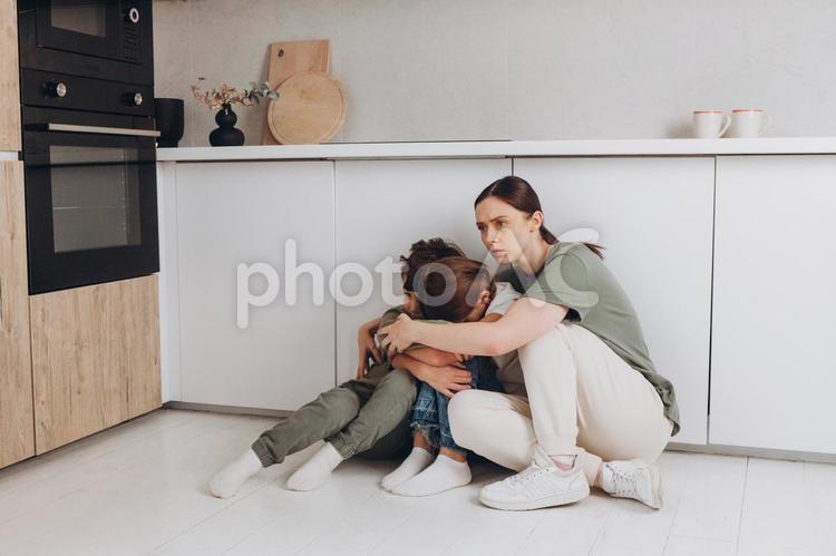 娘と息子を抱きしめる親子 母親,姉弟,女の子の写真素材