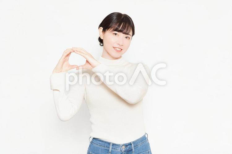 白い背景の前に立ってOKのジェスチャーをする女性 ok,yes,はいの写真素材