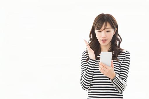 若い女性 ボーダー スマートフォン 驚く 若い女性 ボーダー スマートフォン 驚く スマートフォン,驚く,調べるの写真素材