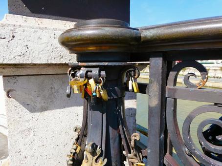 橋に架けられたたくさんの南京錠の写真