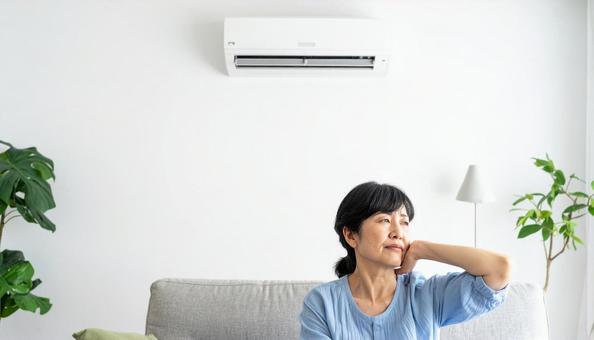 冷房が強すぎて寒がる体調不良のシニア女性 冷房が強すぎて寒がる体調不良のシニア女性の写真