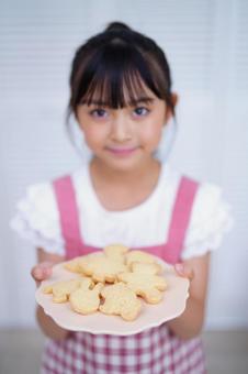 焼けたクッキーをもって微笑む女の子 女の子,クッキー,持つの写真素材