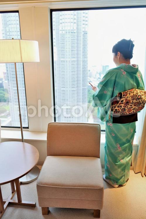 ホテルのゲストルームに着いてスマホを見る和服姿の女性 和服,女性,ゲストルームの写真素材
