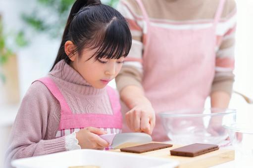 真剣な表情で板チョコを刻む女の子 女の子,チョコレート,包丁の写真素材