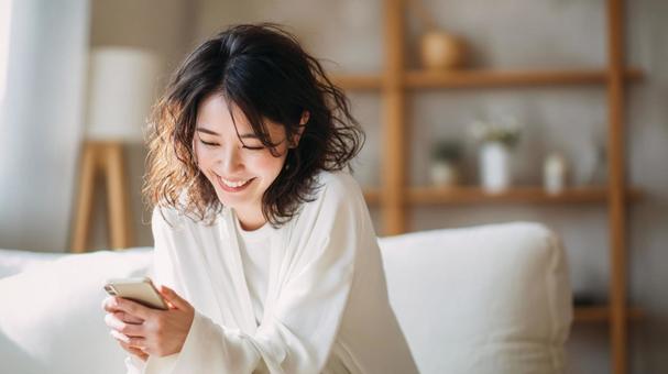 スマホで笑う女性 スマホで笑う女性の写真