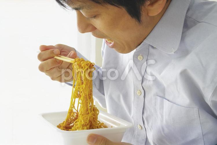 カップ焼きそばを食べる中年男性 ソース焼きそば,カップ焼そば,焼きそばの写真素材