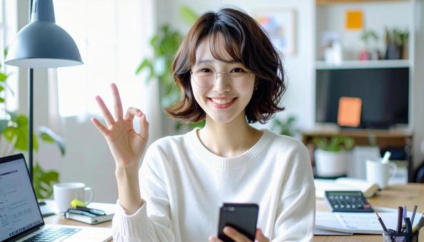 家計がうまくいきスマホ片手に微笑む女性 家計がうまくいきスマホ片手に微笑む女性の写真