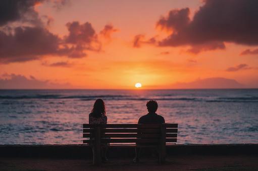 夕日を見つめる二人のシルエット 夕日を見つめる二人のシルエットの写真